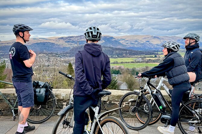 The Stirling City & Beyond Bike Tour: Highlights & Hidden Gems - University of Stirling: modern architecture with mountains behind it